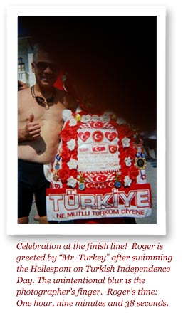 Celebration at the finish line!  Roger is greeted by “Mr. Turkey” after swimming the Hellespont on Turkish Independence Day.  The unintentional blur is the photographer’s finger.  Roger’s time:  One hour, nine minutes and 38 seconds.